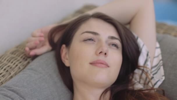 Молода жінка розслабляється на дивані — стокове відео