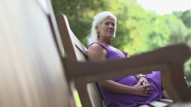 Женщина сидит на скамейке — стоковое видео