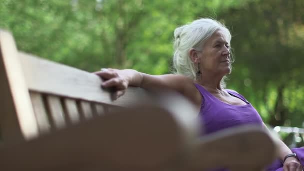 Kvinnan sitter på bänken — Stockvideo