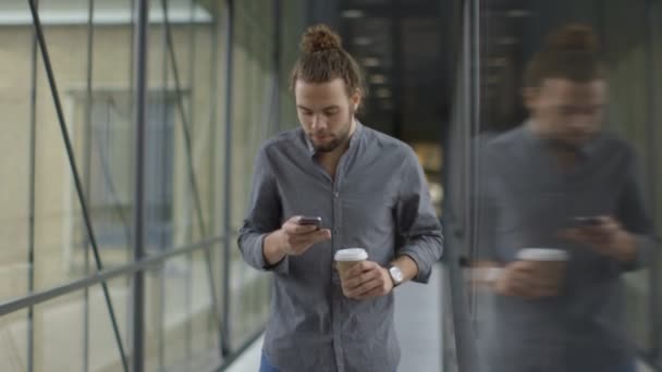 Hombre usando el teléfono móvil en el pasillo — Vídeos de Stock