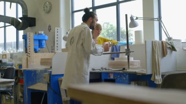 Male potter teaching pottery to woman — Stock Video