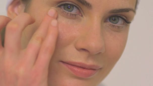 Mujer aplicando crema para los ojos — Vídeo de stock