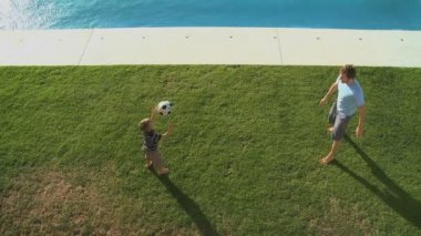 Baba oğul futbol oynuyor.