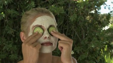Salatalık ile yüz maskesi giyen kadın