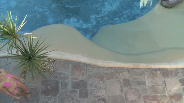 Woman walking past swimming pool — Stock Video