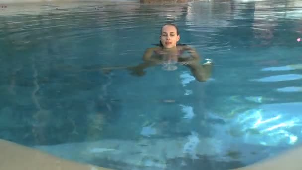 Vrouw zwemmen in het zwembad — Stockvideo