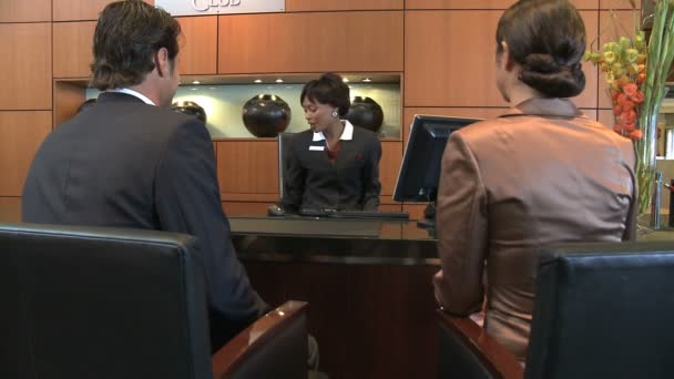 Businesspeople checking in reception desk — Stock Video