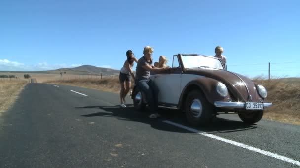 Amigos empujando un coche — Vídeos de Stock