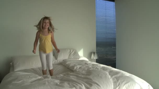 Mädchen springt auf Bett — Stockvideo