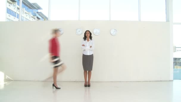 Mujer de negocios de pie y personas que pasan caminando — Vídeo de stock