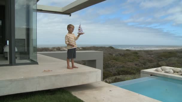 Niño jugando con juguete barco — Vídeos de Stock