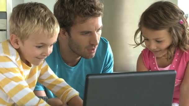 Vater und Kinder schauen auf Laptop — Stockvideo