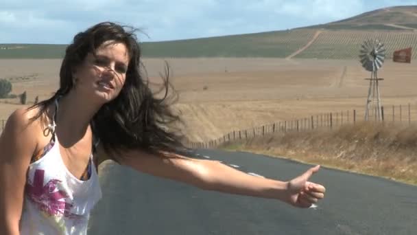 Молодая женщина автостопом — стоковое видео