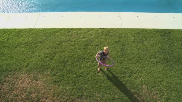 Boy playing with plastic hoop on yard — Stock Video