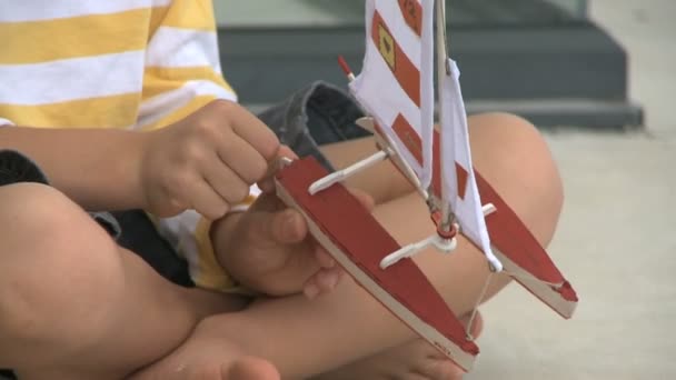 Niño jugando con juguete barco — Vídeos de Stock