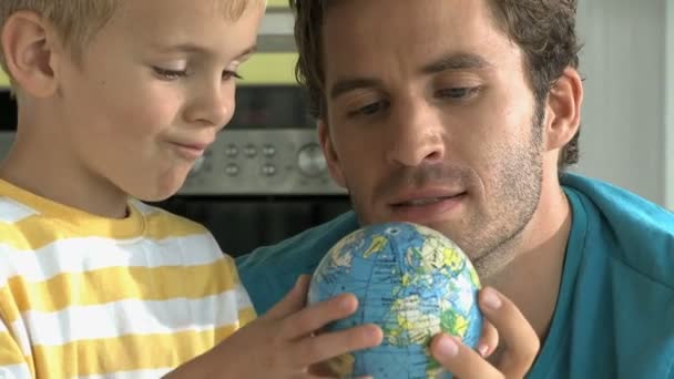 Père et fils regardant le globe — Video