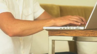 bir dizüstü bilgisayarda yazarak adam