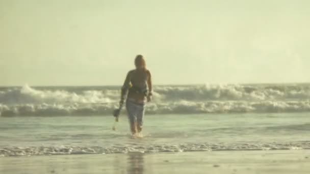 Mujer joven llevando tabla de surf — Vídeo de stock