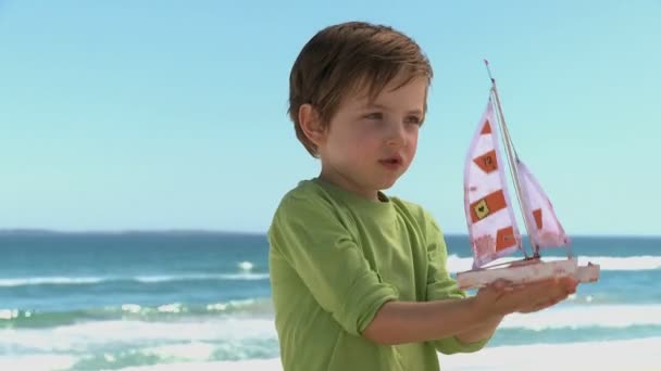 Menino com um barco de brinquedo — Vídeo de Stock