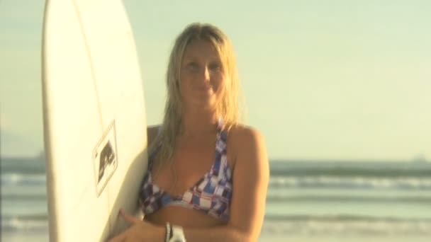 Θηλυκό surfer μεταφέρουν σανίδα του σερφ — Αρχείο Βίντεο