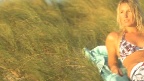 Woman lying down among marram grass — Stock Video