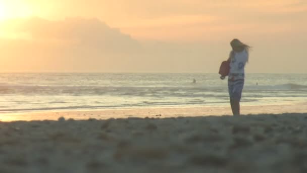 Vrouw die langs het strand loopt — Stockvideo