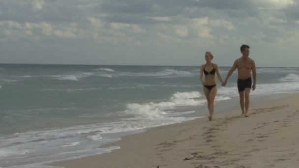 Pareja cogida de la mano una playa — Vídeo de stock