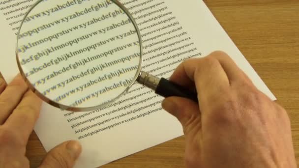 Male looking through magnifying glass — Stock Video