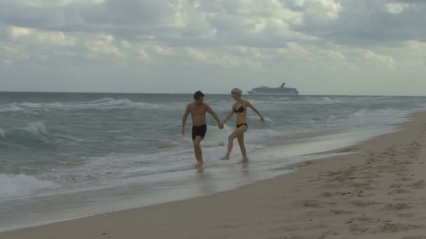 Paar hält Händchen am Strand — Stockvideo