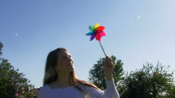 Kvinna som blåser på en vindsnurra — Stockvideo
