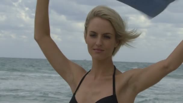 Жінка, що обмотує рушник на пляжі — стокове відео