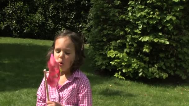Girl blowing a pinwheel — Stock Video