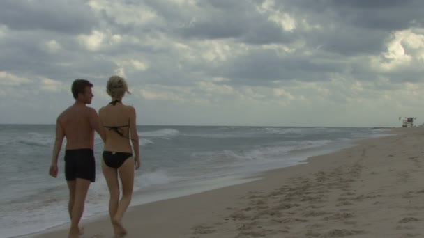 Paar hält Händchen am Strand — Stockvideo