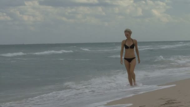Женщина, идущая по пляжу — стоковое видео