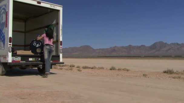 Female lifting drum out of a van — Stock Video