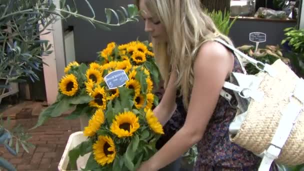 Женщина покупает цветы на цветочном рынке — стоковое видео