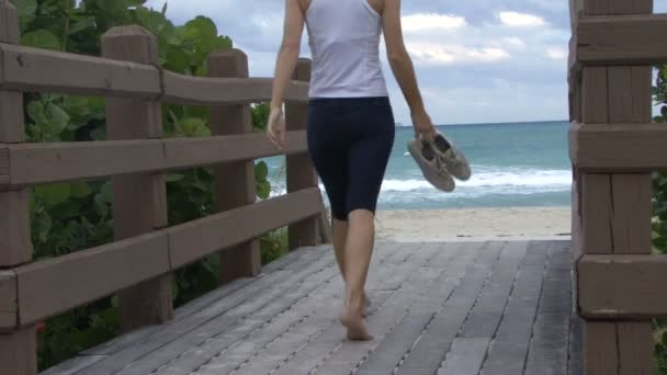 Female walking towards a beach — Stock Video