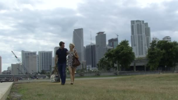 Mannelijke en vrouwelijke lopen in een park met — Stockvideo