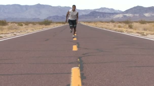 Мужчина бежит по дороге — стоковое видео