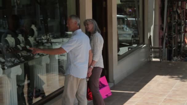 Casal olhando para vitrine — Vídeo de Stock