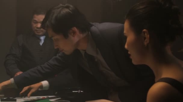 Бізнесмени і жінки грають в рулетку — стокове відео