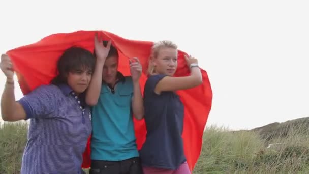 Teenagers playing with red blanket — Stock Video