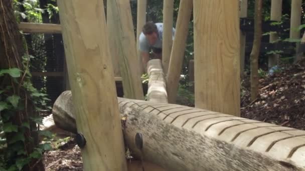 Hombre arrastrándose sobre la barra de equilibrio — Vídeo de stock