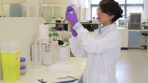 Вчений дивиться на рідину в лабораторії — стокове відео