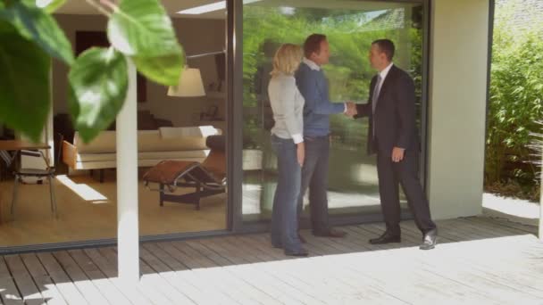 Couple with estate agent in front of house — Stock Video