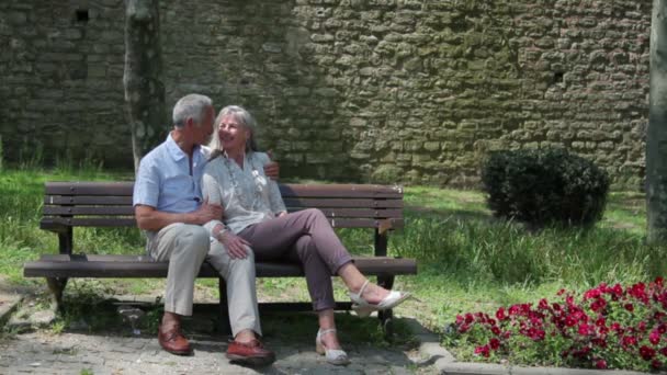 Paar umarmt sich auf Bank im Park — Stockvideo