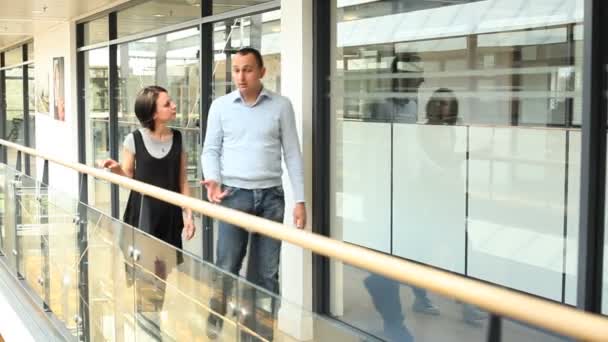Empresario y mujer caminando en edificio de oficinas — Vídeo de stock