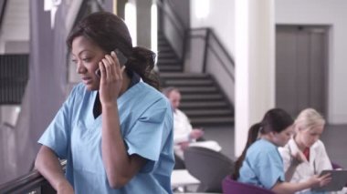 Cep telefonu üzerinde konuşurken kadın hemşire
