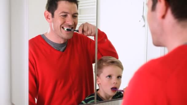 Отец и сын чистят зубы. — стоковое видео