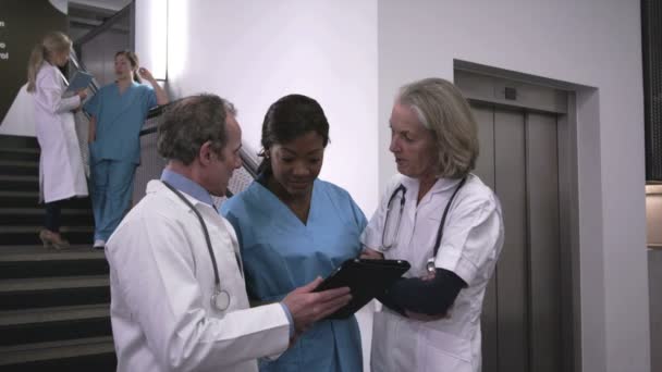 Врачи и медсестра с помощью цифрового планшета — стоковое видео